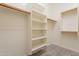 An organized walk-in closet featuring white walls, wood rods and shelves at 5721 W Molly Ln, Phoenix, AZ 85083