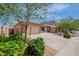Wide view of a tan home with a three car garage, desert landscaping, and mountain views at 5721 W Molly Ln, Phoenix, AZ 85083