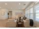 Open-concept living room with large windows, neutral furniture, and seamless connection to kitchen at 5721 W Molly Ln, Phoenix, AZ 85083