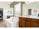 Bright main bathroom featuring dual sinks, separate tub, wood cabinets, and updated fixtures at 5721 W Molly Ln, Phoenix, AZ 85083