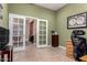 Spacious home office featuring french doors that provide a view into another room with a piano at 5721 W Molly Ln, Phoenix, AZ 85083