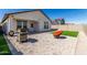 This backyard features a grill, an orange chair, and artificial grass at 5875 N 195Th Dr, Litchfield Park, AZ 85340