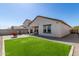 This backyard features artificial grass, a seating area, and string lights at 5875 N 195Th Dr, Litchfield Park, AZ 85340