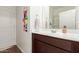 This bathroom features dark wood cabinetry, a wide mirror, and a shower/tub combo at 5875 N 195Th Dr, Litchfield Park, AZ 85340