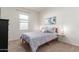 This bedroom features a cozy queen bed, neutral carpeting, and calming blue artwork at 5875 N 195Th Dr, Litchfield Park, AZ 85340