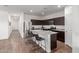 Spacious kitchen with an island that includes sitting for four people, modern appliances, and wood flooring at 5875 N 195Th Dr, Litchfield Park, AZ 85340
