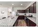 Modern kitchen features granite countertops, stainless steel appliances, and wood flooring at 5875 N 195Th Dr, Litchfield Park, AZ 85340