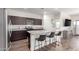 Open kitchen design featuring an island with seating, granite countertops, and dark cabinets at 5875 N 195Th Dr, Litchfield Park, AZ 85340