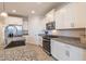 Modern kitchen featuring granite countertops, stainless steel appliances, and crisp white cabinetry throughout at 6810 W Pedro Ln, Laveen, AZ 85339