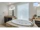 Bathroom featuring a soaking tub, custom tile surround, and glass block window at 7745 E Calle De Las Brisas --, Scottsdale, AZ 85255