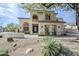 Elegant two-story home with a stucco facade, decorative wrought iron door, and desert landscaping at 7745 E Calle De Las Brisas --, Scottsdale, AZ 85255