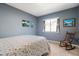 Serene bedroom with ocean-themed art, soft blue walls, and a cozy rocking chair near a sunlit window at 7800 E Via Del Futuro E --, Scottsdale, AZ 85258