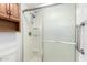 Bright bathroom featuring a walk-in shower with glass doors and a wood cabinet at 849 E Lancaster Cir, Florence, AZ 85132