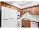 Bright kitchen features wooden cabinets, white appliances, and a stainless steel double sink at 849 E Lancaster Cir, Florence, AZ 85132
