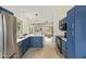 Modern kitchen featuring stainless steel appliances, stylish blue cabinetry, and an open layout to the living area at 8867 E Avenida Las Noches --, Gold Canyon, AZ 85118