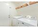 Well-equipped laundry room with washer, dryer, and storage shelves at 8867 E Avenida Las Noches --, Gold Canyon, AZ 85118
