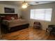 A spacious bedroom with a ceiling fan, wood floors, and a window with blinds at 8870 N 48Th Ln, Glendale, AZ 85302