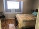 Cozy bedroom featuring a comfortable bed, wood floors, and a bright window at 8870 N 48Th Ln, Glendale, AZ 85302