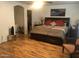 Spacious bedroom with a large bed, wood floors, and an ensuite bathroom and closet at 8870 N 48Th Ln, Glendale, AZ 85302