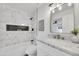 Modern bathroom featuring marble tile, a built-in shower niche, and elegant vanity lighting at 9036 N 51St Ln, Glendale, AZ 85302