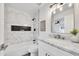 Modern bathroom featuring marble tile, a built-in shower niche, and elegant vanity lighting at 9036 N 51St Ln, Glendale, AZ 85302