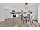 Modern kitchen with stainless steel appliances, white cabinets, and an eat-in dining area at 9036 N 51St Ln, Glendale, AZ 85302