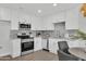 Kitchen features stainless steel appliances, white cabinets, and modern fixtures at 9036 N 51St Ln, Glendale, AZ 85302