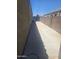 View of the property's clean side yard with concrete pathway leading to the front of the house at 9302 W Georgia Ave, Glendale, AZ 85305