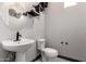 Stylish half-bathroom with sleek fixtures, modern decor, and a pedestal sink at 9302 W Georgia Ave, Glendale, AZ 85305