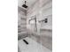 Sleek walk-in shower with designer tile, rainfall showerhead, and built-in niche at 9302 W Georgia Ave, Glendale, AZ 85305