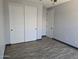 Neutral bedroom featuring wood-look floors, large closet with sliding doors, and modern gray walls at 9302 W Georgia Ave, Glendale, AZ 85305