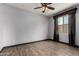 Bedroom with hardwood floors, a ceiling fan, and a large window with curtains at 9302 W Georgia Ave, Glendale, AZ 85305