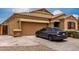 Attractive single-story home with a two-car garage, desert landscaping, and a modern car at 9302 W Georgia Ave, Glendale, AZ 85305