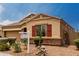 Close-up of tan-colored exterior with red shutters and desert landscaping at 9302 W Georgia Ave, Glendale, AZ 85305