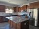Spacious kitchen boasting stainless steel appliances, wood cabinets, granite countertops and a large island at 9302 W Georgia Ave, Glendale, AZ 85305