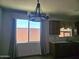Eat-in kitchen featuring a modern chandelier, window with patterned curtain, and stainless steel sink at 9302 W Georgia Ave, Glendale, AZ 85305