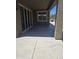 A covered patio area with a concrete floor, featuring a sliding glass door and a window at 9302 W Georgia Ave, Glendale, AZ 85305