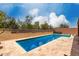 Backyard pool featuring travertine tile decking, surrounded by lush landscaping and privacy walls at 9302 W Georgia Ave, Glendale, AZ 85305