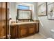 Bathroom vanity featuring granite counters, wooden cabinets, framed mirror, and decorative accents at 9560 E Preserve Way, Scottsdale, AZ 85262