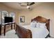 Bright bedroom features a beautiful wood bed frame, neutral walls, a ceiling fan, and a flat-screen TV at 9560 E Preserve Way, Scottsdale, AZ 85262