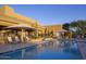 Community pool area with lounge chairs, sun umbrellas, and lush landscaping around pool at 9560 E Preserve Way, Scottsdale, AZ 85262