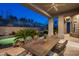 Covered patio with a dining table and chairs, overlooking the pool at 9560 E Preserve Way, Scottsdale, AZ 85262