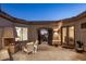Outdoor patio includes a fireplace and seating area with an arched gateway to the front yard at 9560 E Preserve Way, Scottsdale, AZ 85262