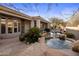 Backyard pool with natural stone accents, lush landscaping, and an outdoor dining area at 9560 E Preserve Way, Scottsdale, AZ 85262