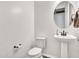 Classic white powder room with a pedestal sink, round mirror, and dark wood-look flooring at 9821 E Supernova Dr, Mesa, AZ 85212