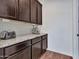 A kitchen area featuring dark cabinets, granite countertops, stainless steel appliances and wood flooring at 9821 E Supernova Dr, Mesa, AZ 85212