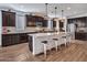 Spacious kitchen featuring dark cabinetry, a large granite island with seating, and modern stainless steel appliances at 9821 E Supernova Dr, Mesa, AZ 85212