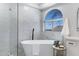 Modern bathroom featuring a freestanding tub, marble tile walls, and a large arched window for natural light at 1012 E Rosebud Dr, San Tan Valley, AZ 85143