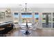 Bright dining area with a modern chandelier, transparent chairs and a view of the backyard and pool at 1012 E Rosebud Dr, San Tan Valley, AZ 85143