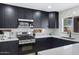 Modern kitchen features black cabinets, stainless steel appliances, white countertops, and white subway tiles at 1012 E Rosebud Dr, San Tan Valley, AZ 85143